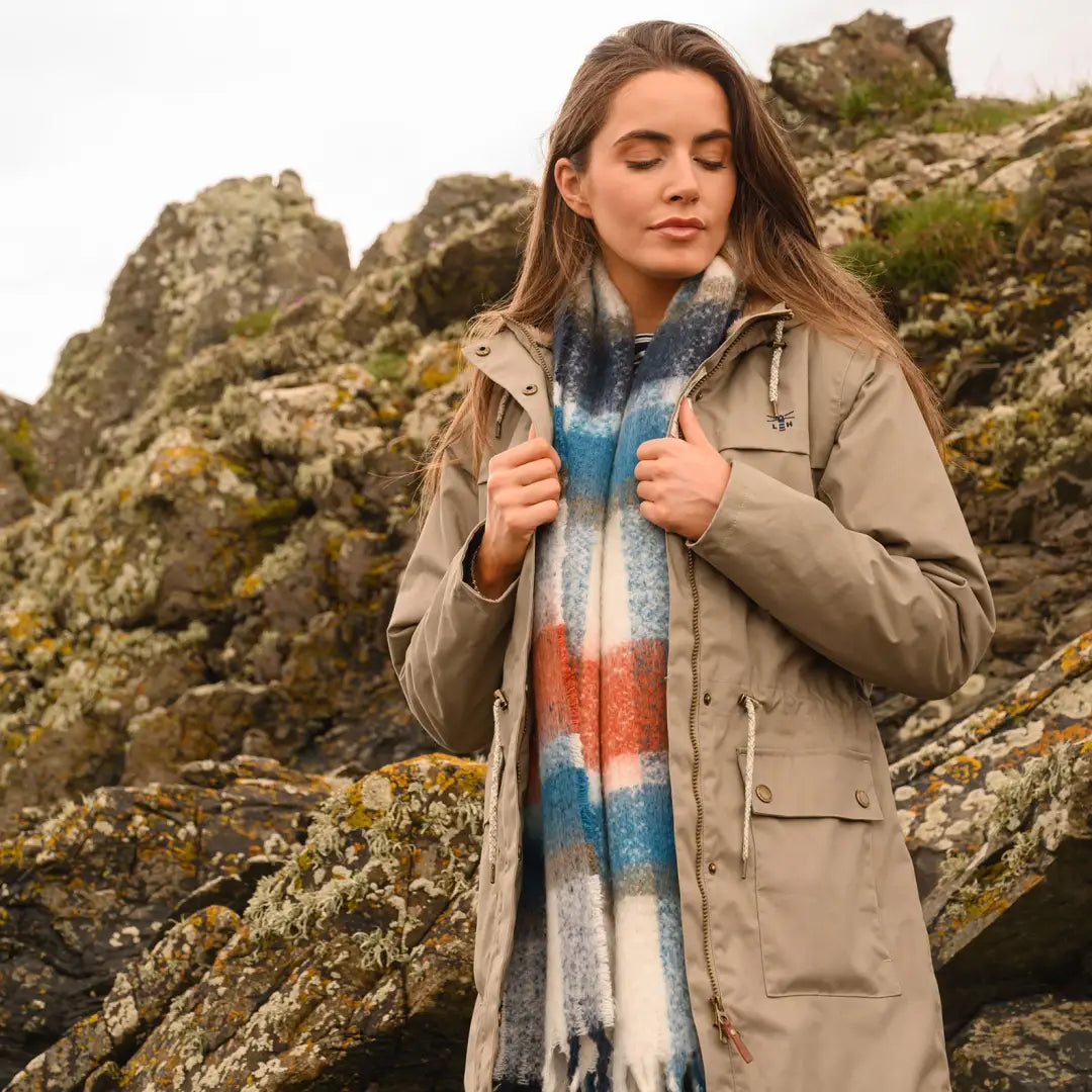 Woman in a beige Isobel Coat and vibrant scarf enjoying the outdoors in country clothing