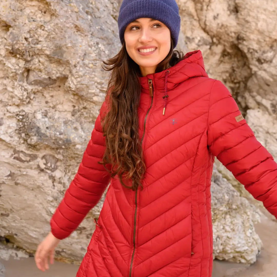 Woman in a bright red puffer jacket and purple knit hat in Lighthouse Laurel Coat