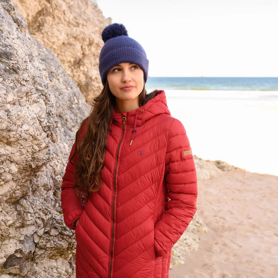 Woman at the beach rocking a Lighthouse Laurel Coat with a blue knit hat