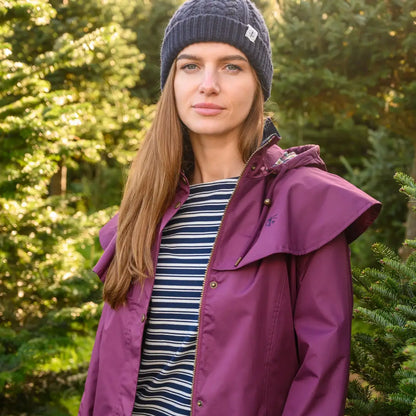 Woman in a purple Lighthouse Outrider 3/4 length ladies waterproof raincoat outdoors