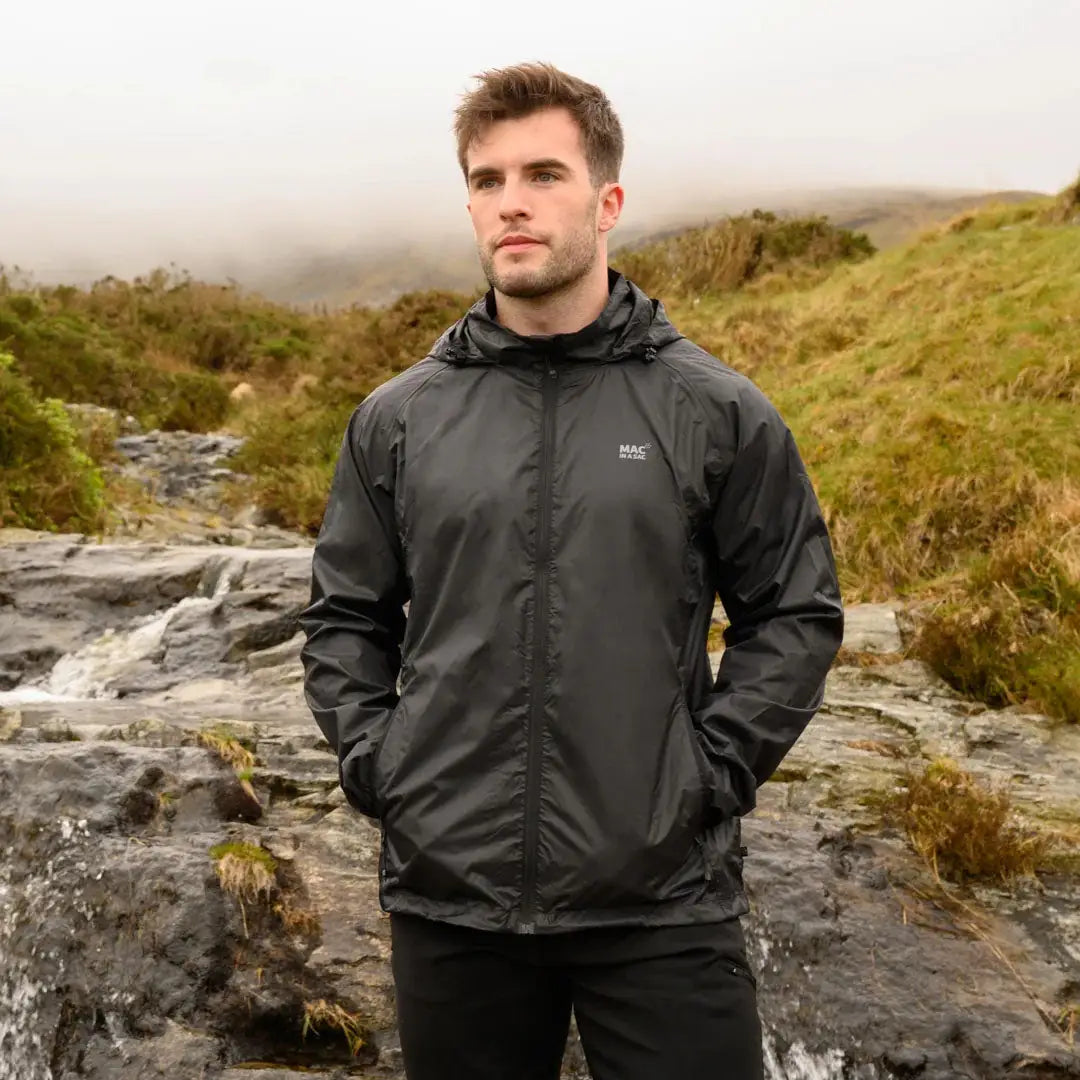 Man in a dark gray Mac in a Sac Origin 2 waterproof jacket enjoying the outdoors