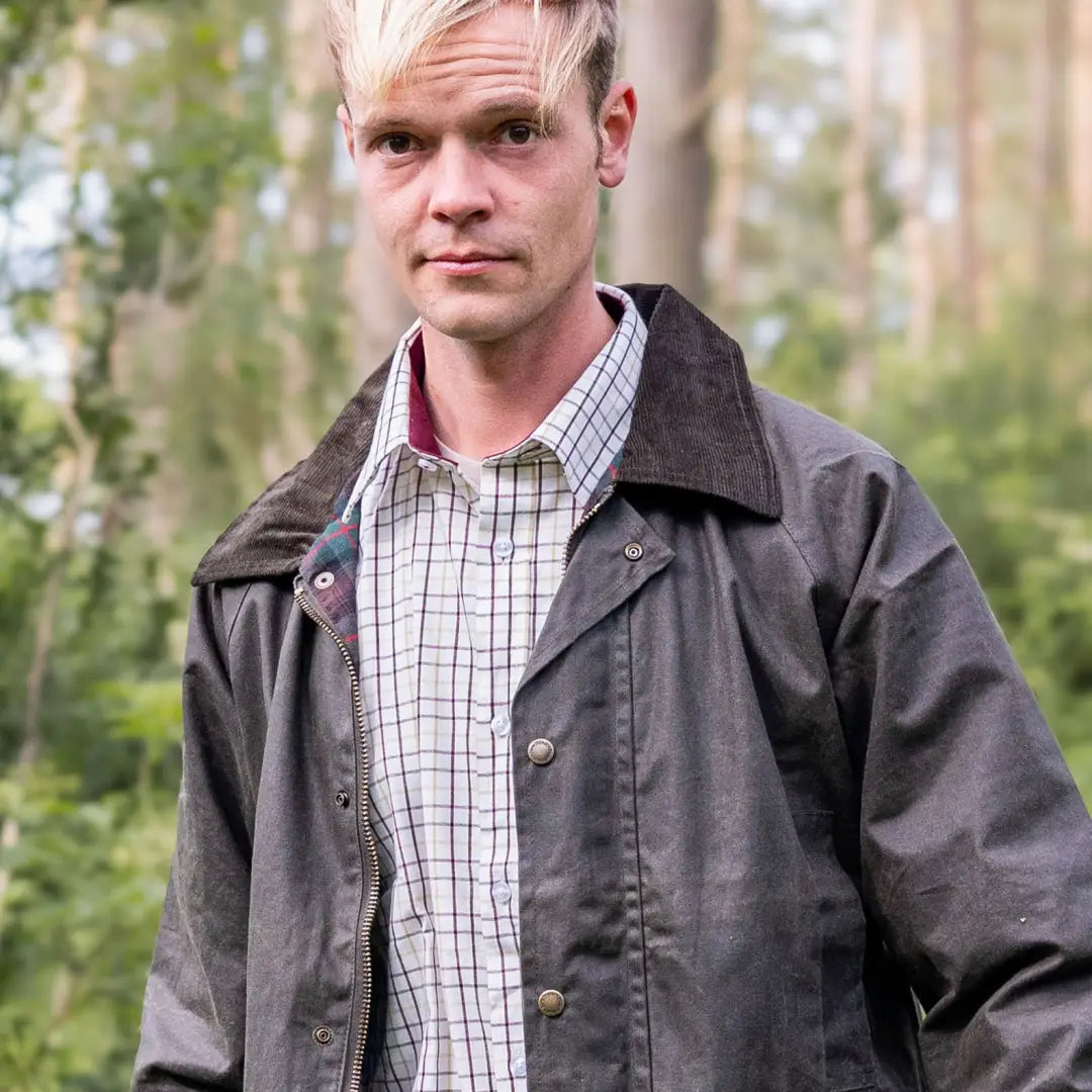 Man in checkered shirt and dark jacket showcasing Mens Classic Antique Wax Jacket outdoors