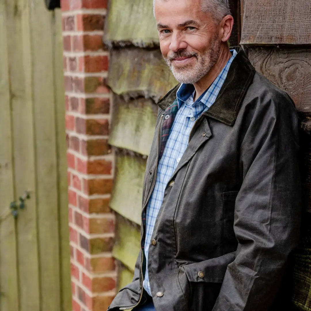 Smiling older man in a dark jacket shows off the Mens Classic Antique Wax Jacket