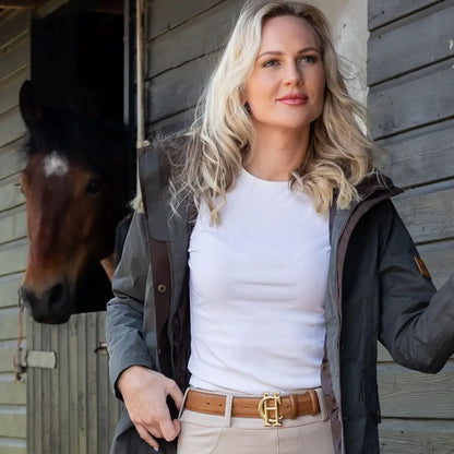 Woman in a white shirt and dark jacket by a horse wearing the Forest Alice Waterproof Coat