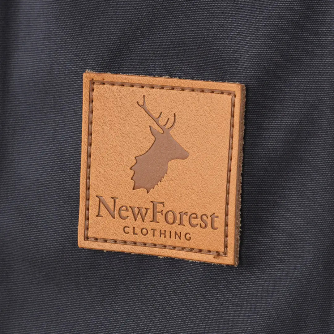 Leather patch featuring NewForest CLOTHING text and deer logo on Alice Waterproof Coat