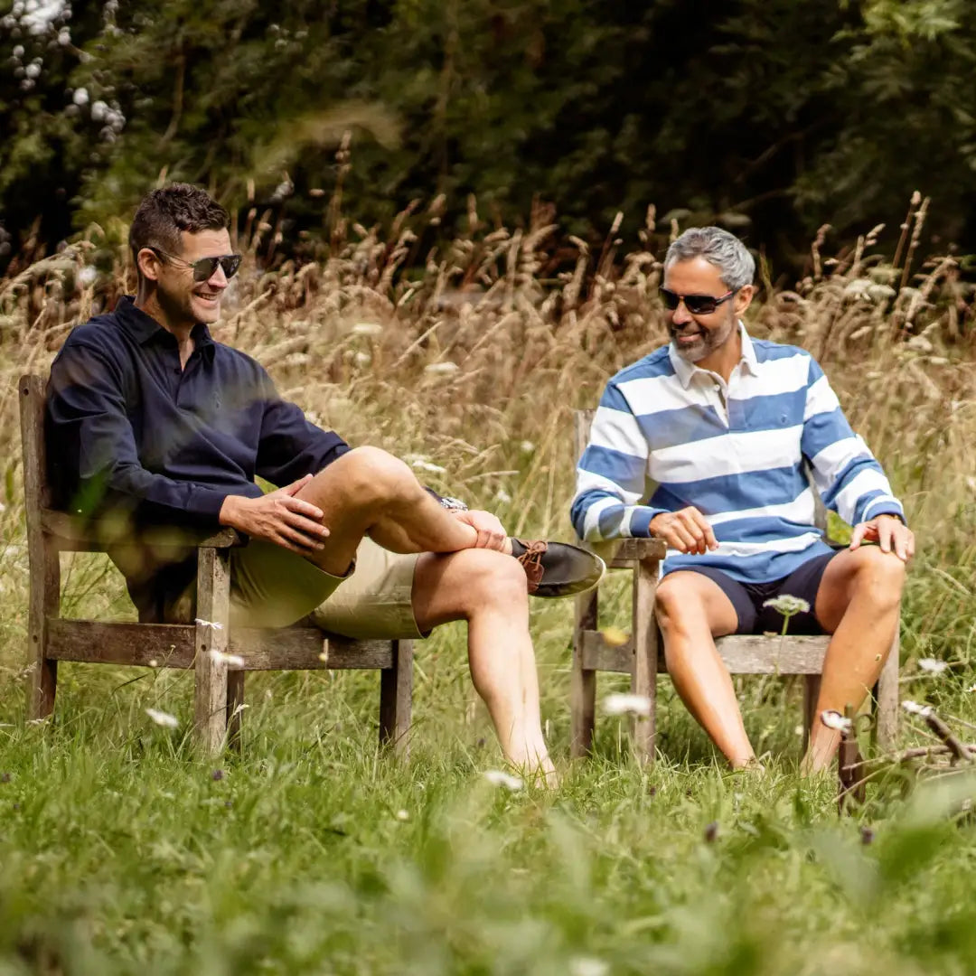 Two men relaxing in wooden chairs wearing New Forest Chino Shorts outdoors