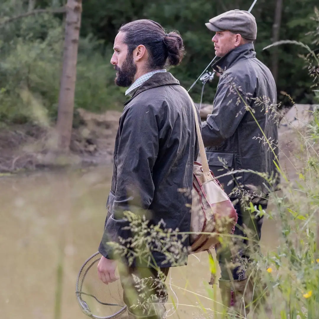 Two men in outdoor gear by water wearing the Mens Classic Antique Wax Jacket