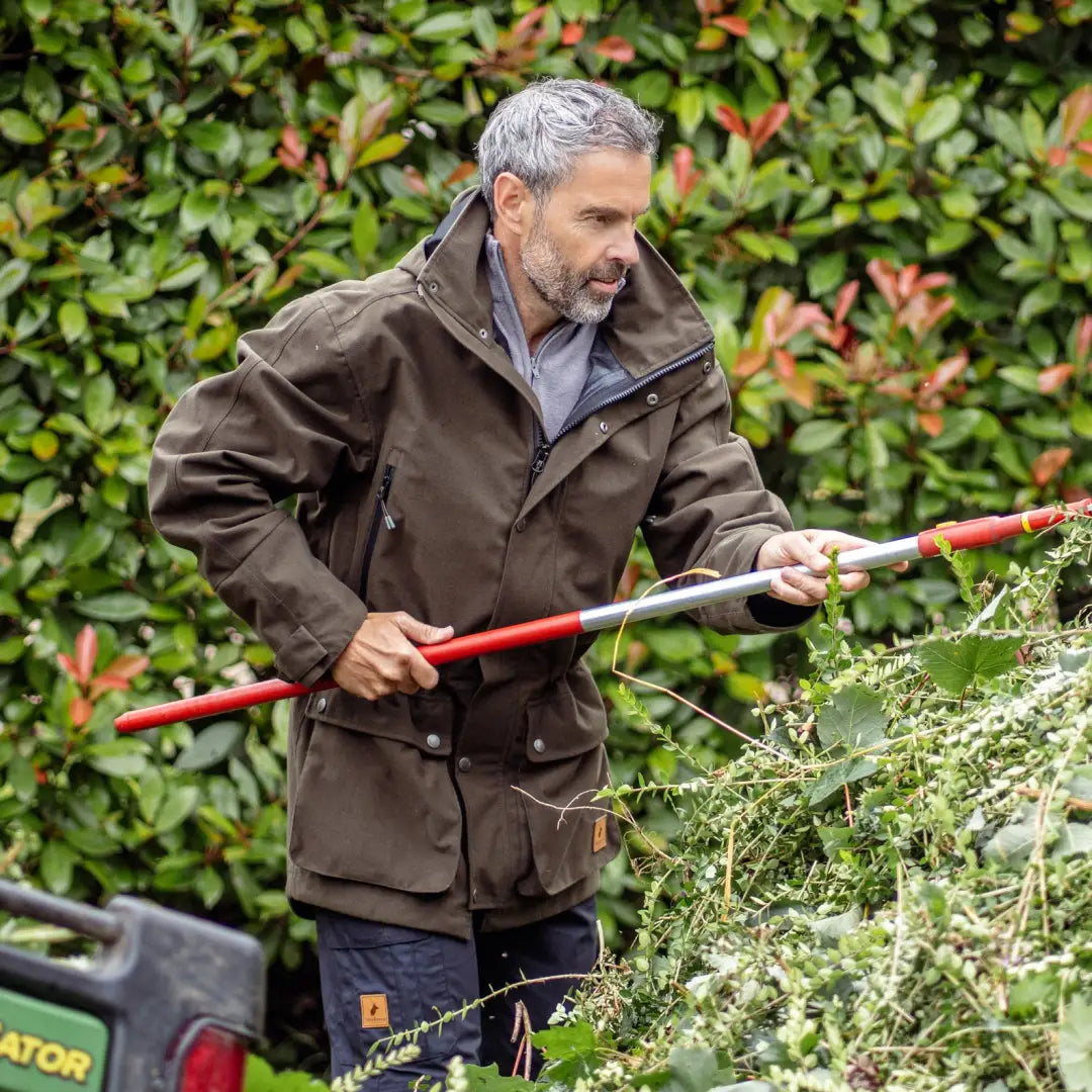 Man with gray hair trims hedges wearing a stylish Forest Country Sport Jacket