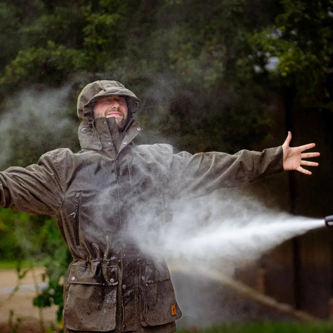 Person in a rain jacket getting sprayed by water in a New Forest Country Sport Jacket