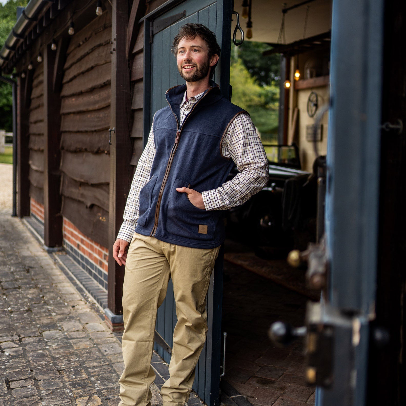 Man in navy vest and khaki pants wearing the New Forest Fleece Gilet