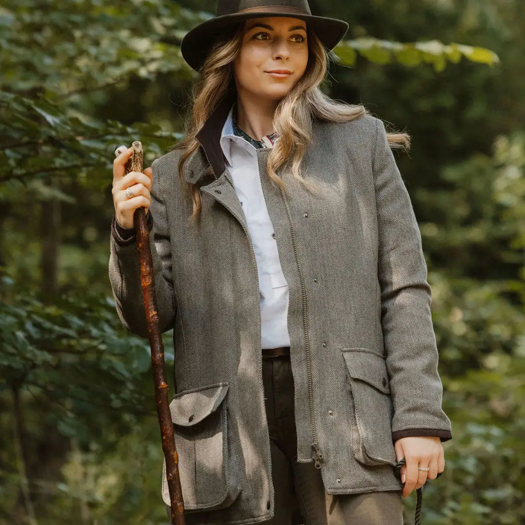 Woman in a gray hat and coat enjoying the outdoors in a stylish Tweed Field Coat