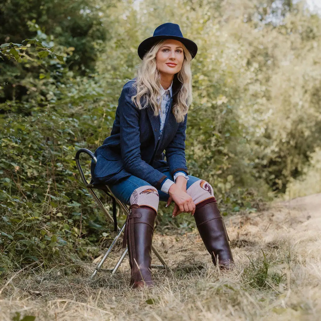 Woman in navy blazer and riding boots sitting outdoors by the Forest Jessica Tweed Field Coat