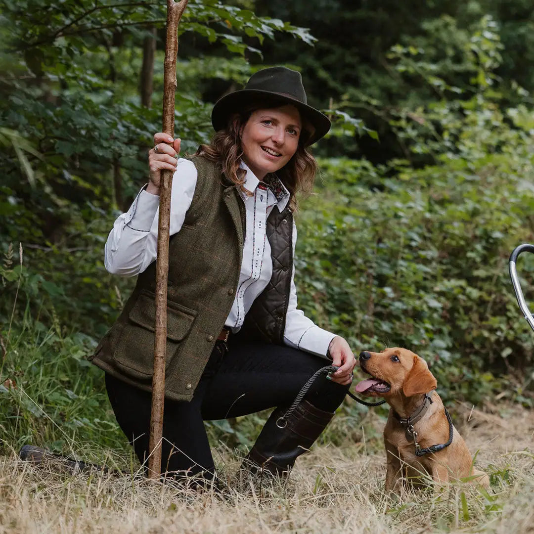 Woman in a Ladies Tweed Gilet enjoying the outdoors with her dog and walking stick