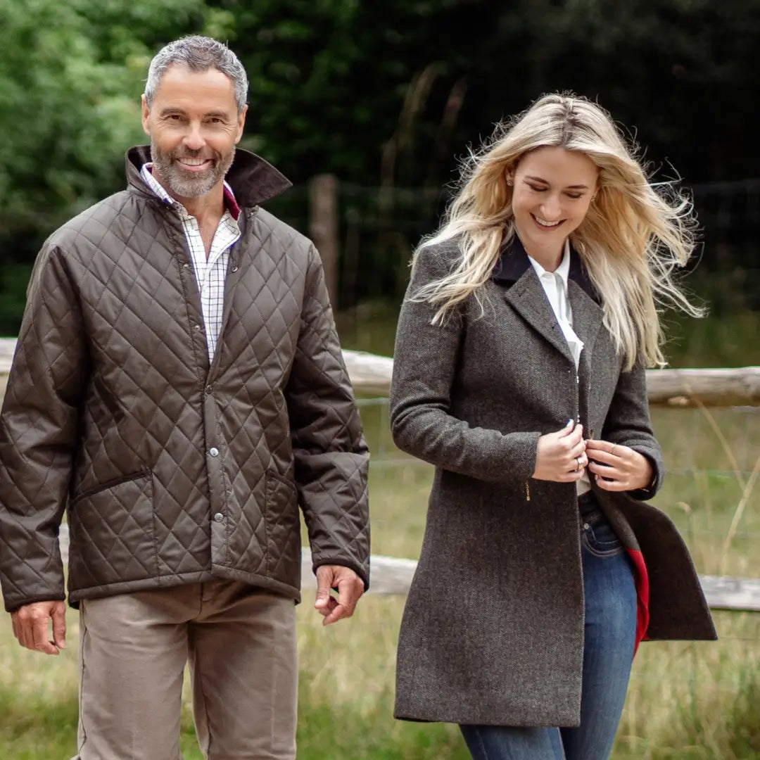 Two people in autumn coats enjoying a stroll in the forest, showcasing Lizzie Tweed