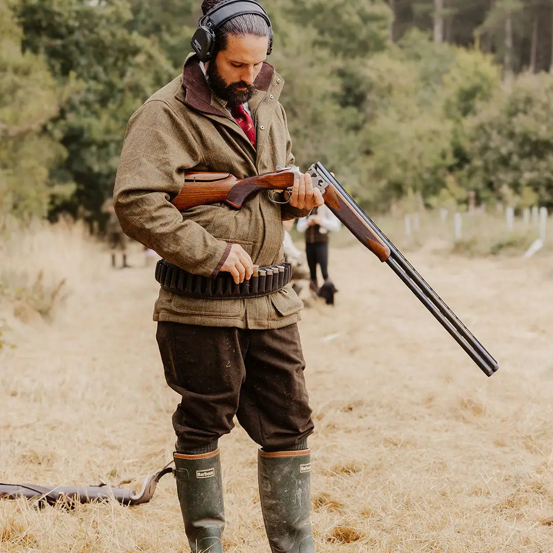 Hunter in traditional gear holding an over-under shotgun, wearing Forest Moleskin Breeks