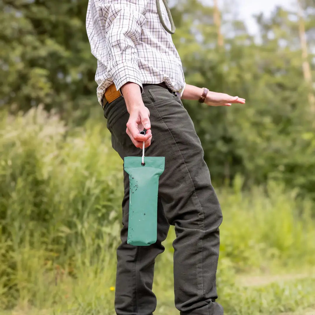 Teal insect trap held in hand, perfect for outdoor adventures in Forest Moleskin Jeans