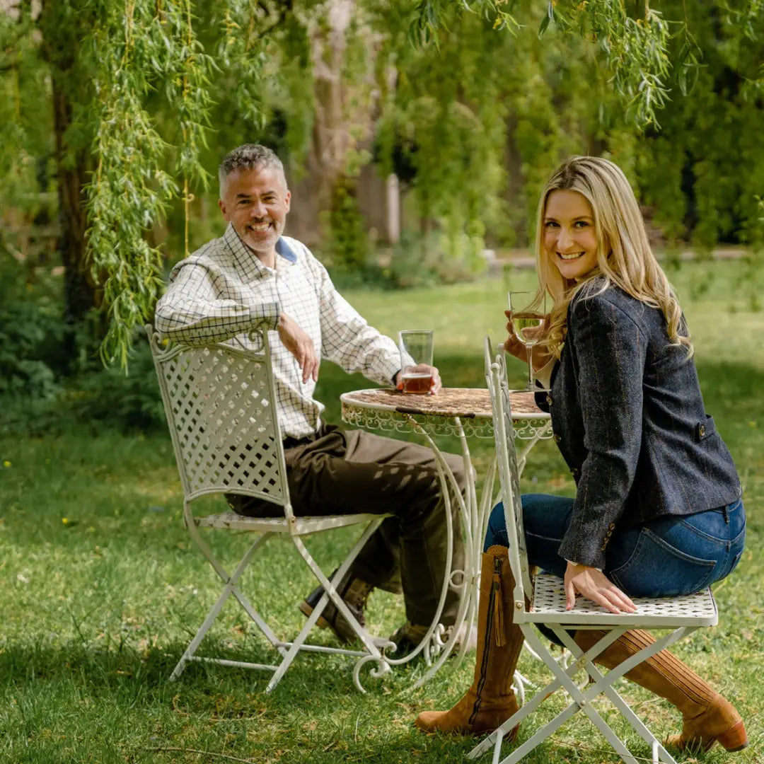 Two friends enjoying drinks at a cozy outdoor table in their Forest Polly Tweed Blazer