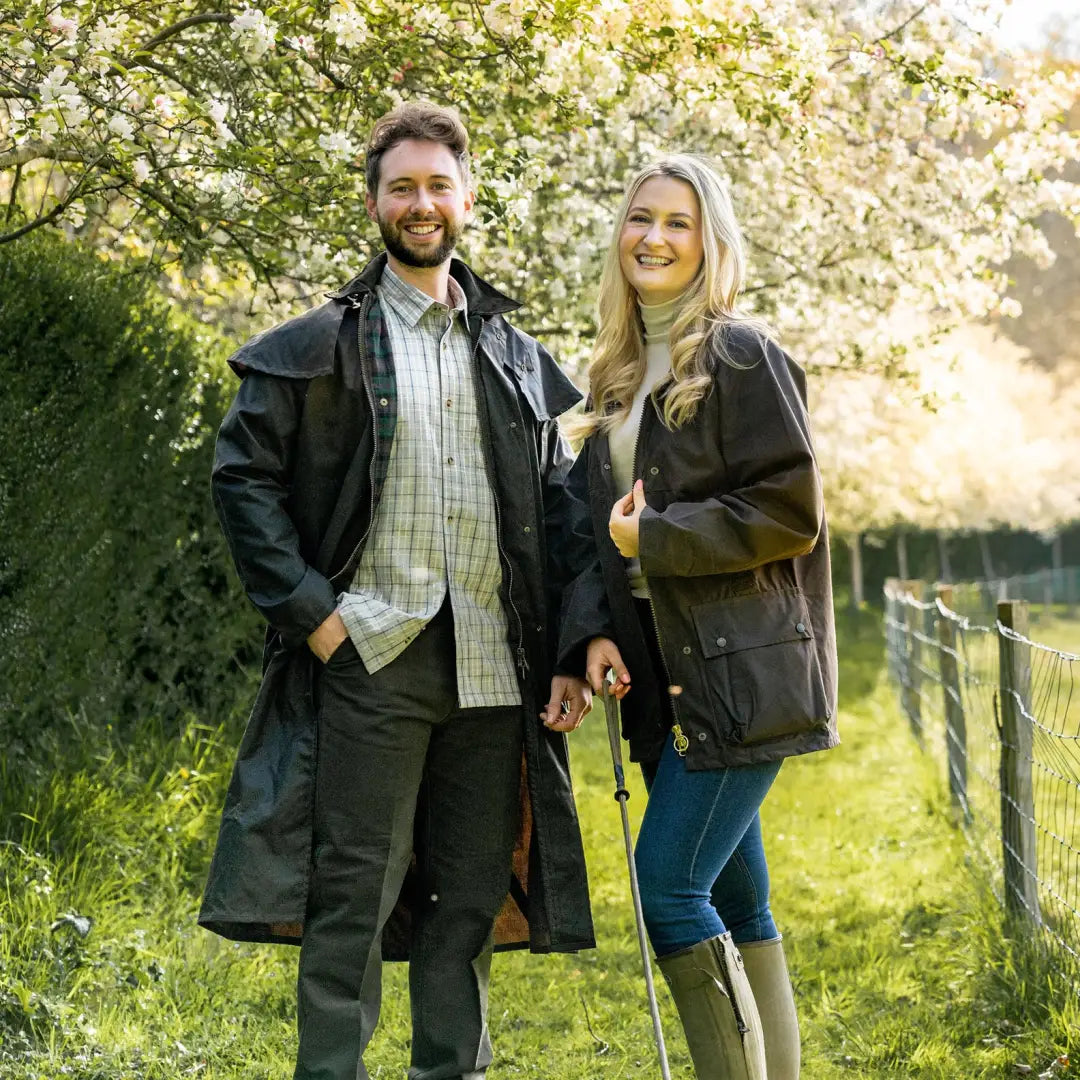 Smiling couple in spring wearing the stylish Stockman Full Length Wax Coat outdoors