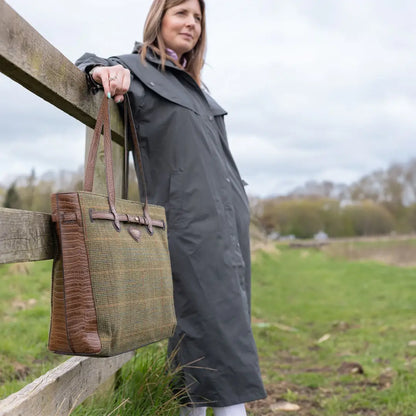 Woman in dark gray New Forest Victoria Cape leaning on a fence, perfect for wet weather