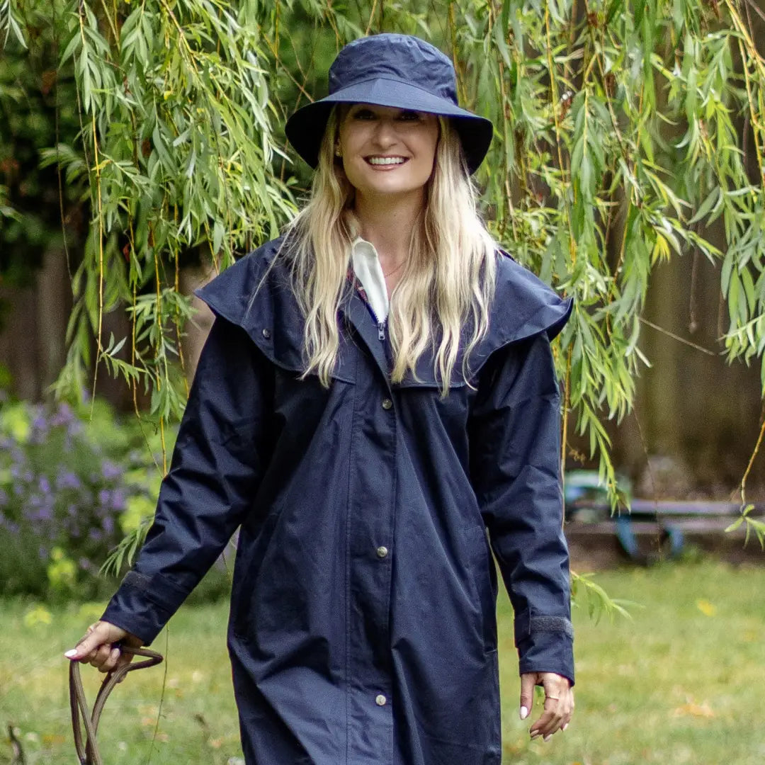 Smiling blonde woman in Navy blue raincoat and Victoria Waterproof Hat