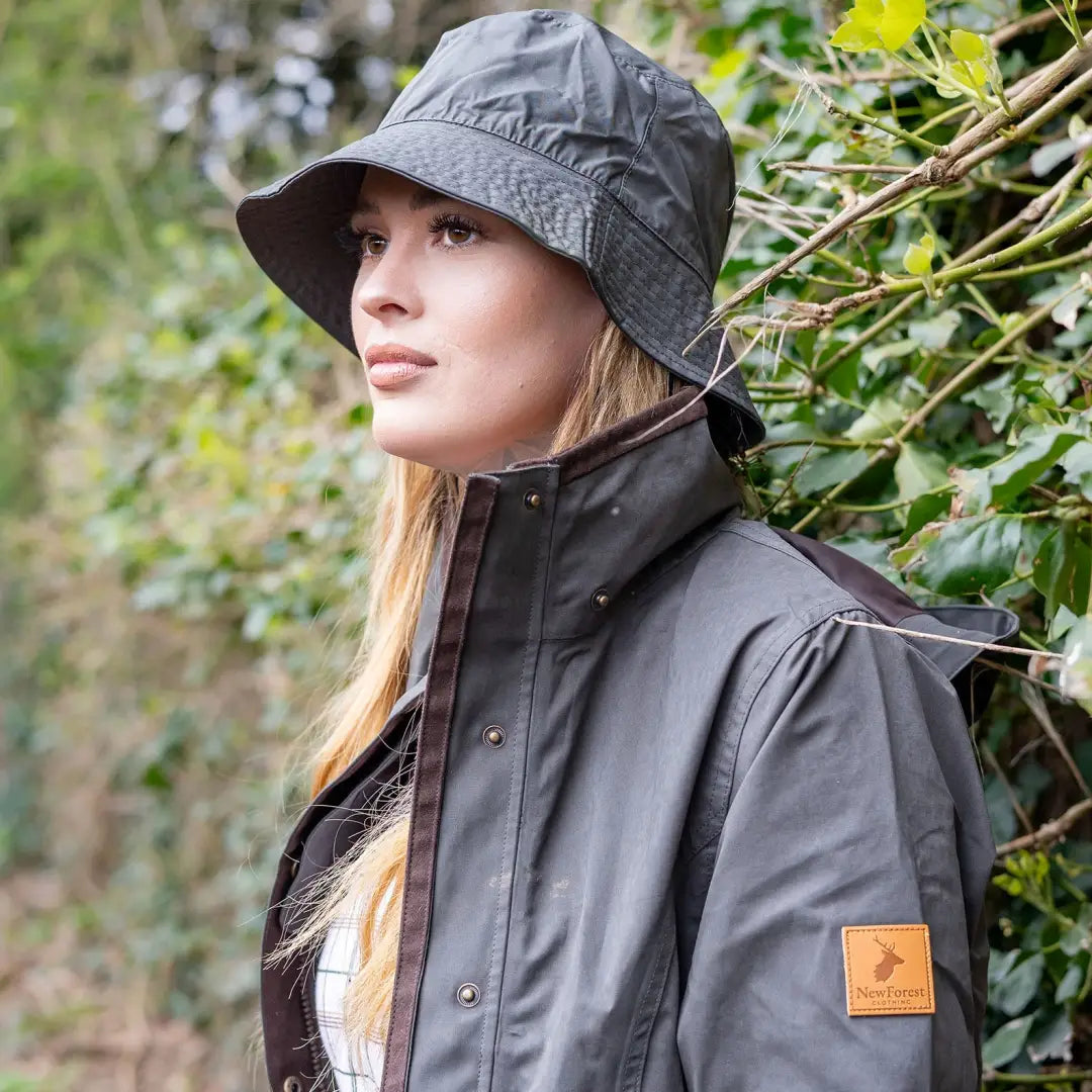 Woman outdoors rocking a Forest Victoria Waterproof Hat in gray rain gear