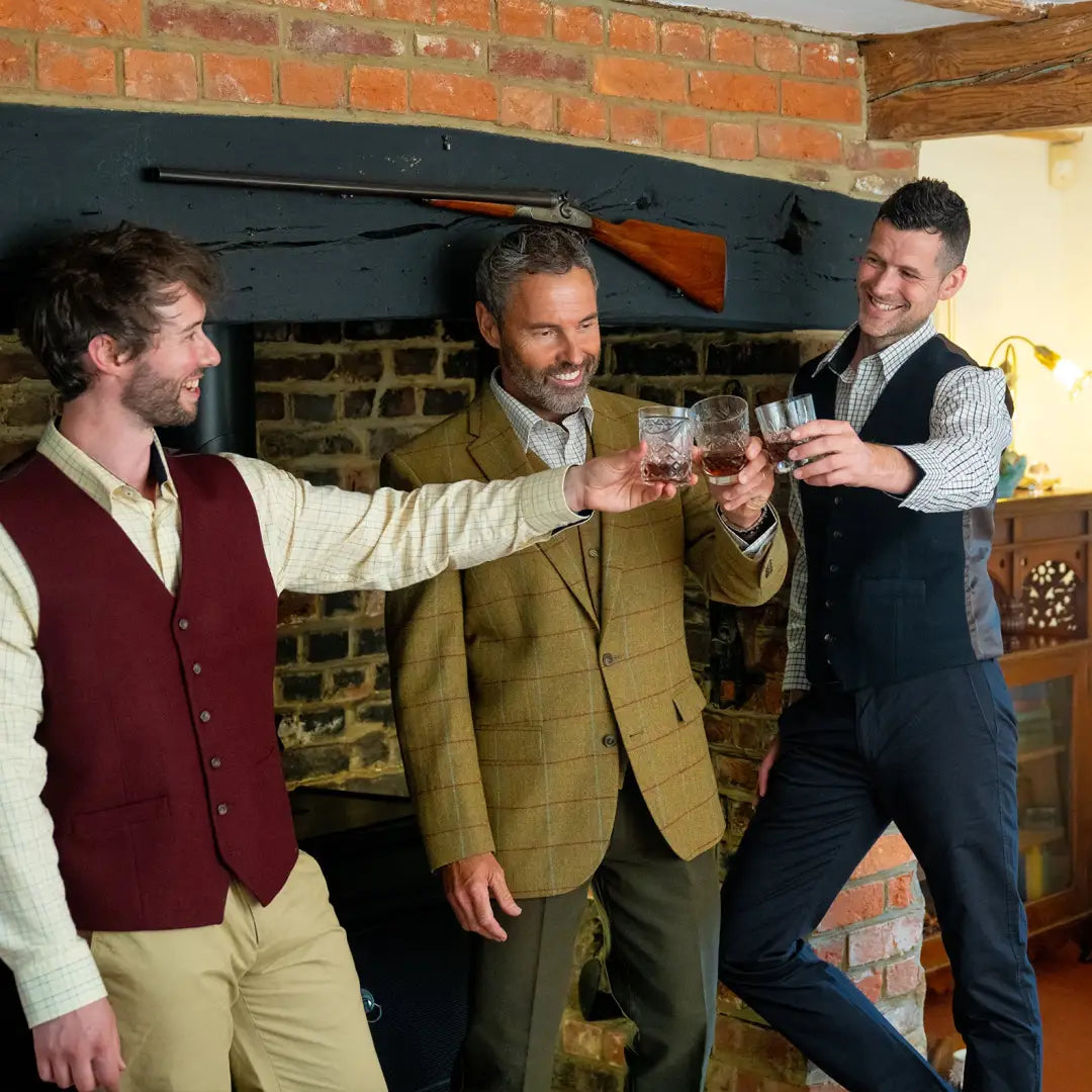 Three men toasting with whiskey, wearing stylish New Forest wool mix waistcoat