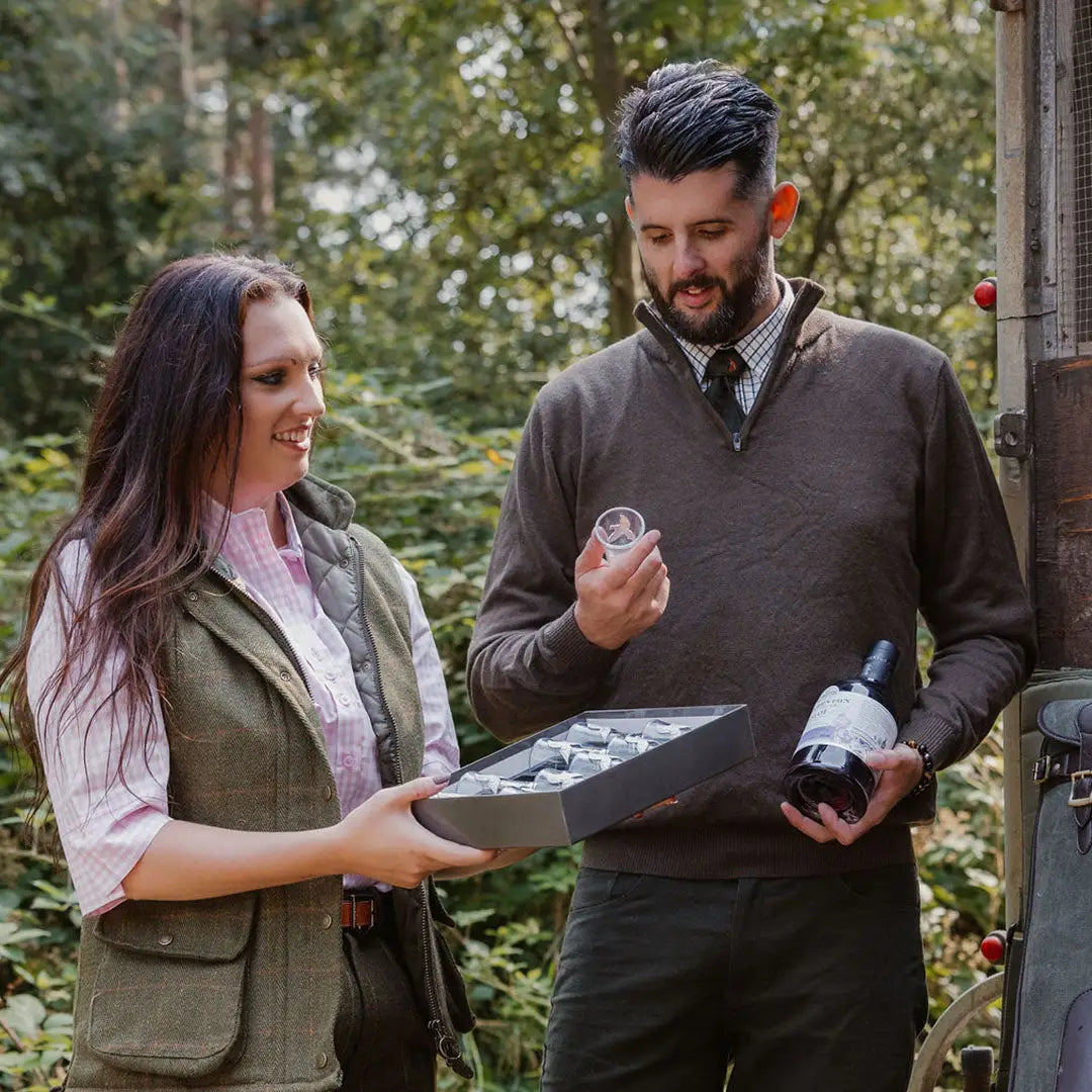 Couple enjoying the outdoors while checking out wine in a cozy zip neck jumper