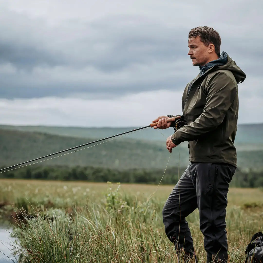 Man in Pinewood Abisko Telluz Jacket fishing outdoors, showcasing lightweight 3-layer style