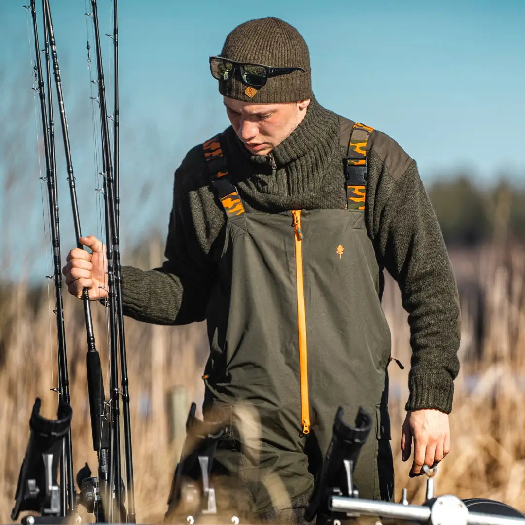 Fisherman in warm gear with fishing rods showcasing Pinewood Bolmen Fishing Trousers