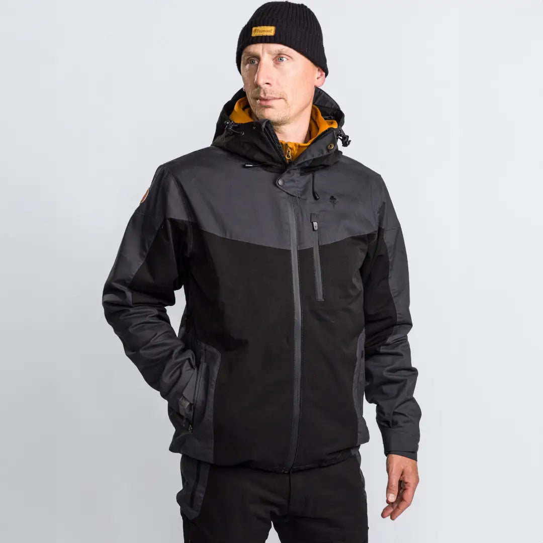 Person in a two-tone Pinewood Finnveden Hybrid Extreme Jacket and black beanie hat