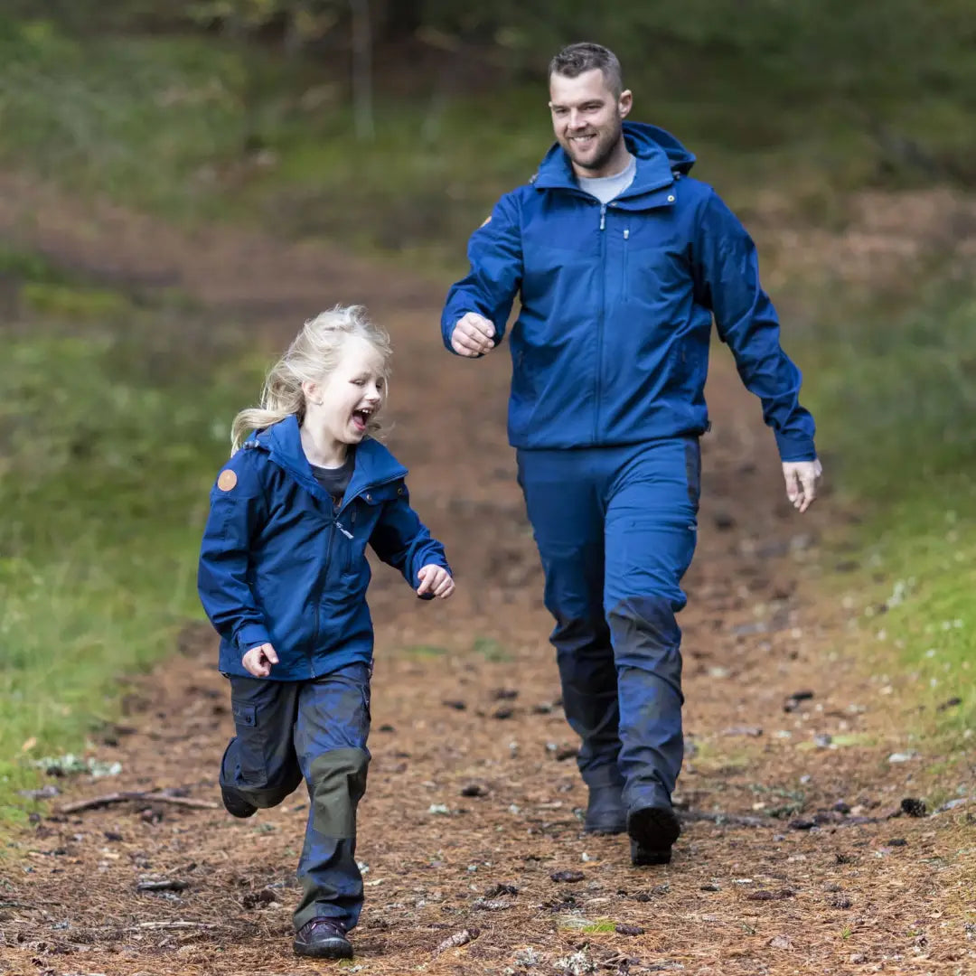 Adult and child in blue jackets enjoying a walk on a dirt path with Pinewood Finnveden Hybrid