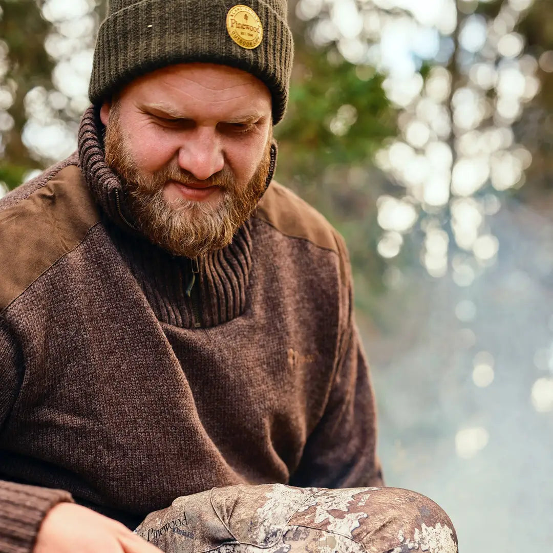 Bearded man in a warm knit hat and Pinewood windproof sweater with high collar