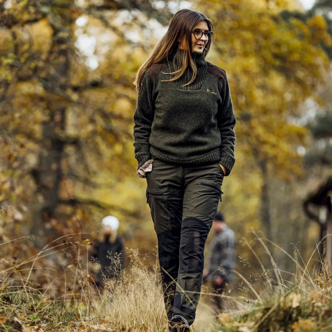 Woman in dark clothes walking through grass wearing Pinewood Ladies Caribou TC Trousers