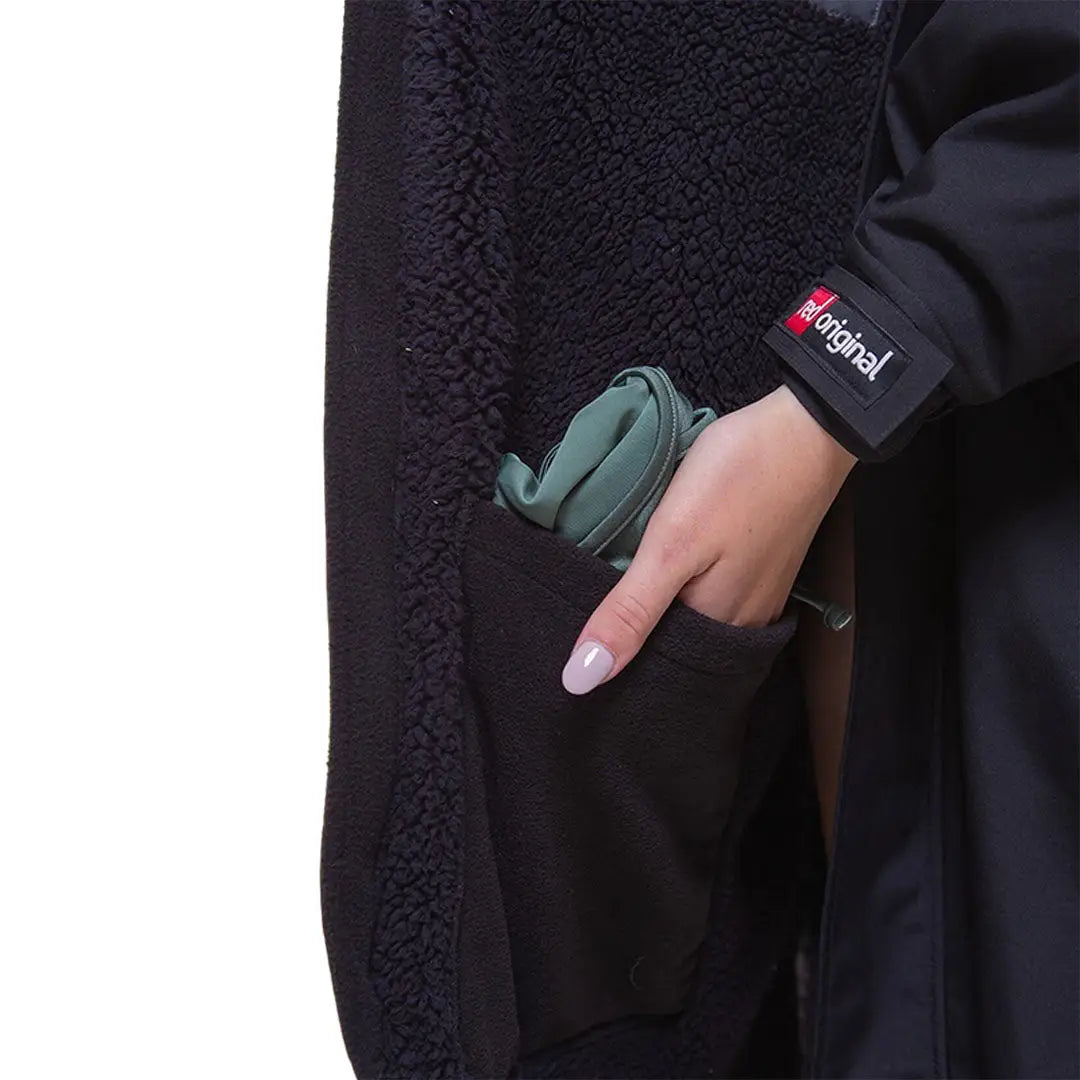 Hand holding a green wallet in coat pocket of Red Pro Change Long Sleeve Evo Jacket