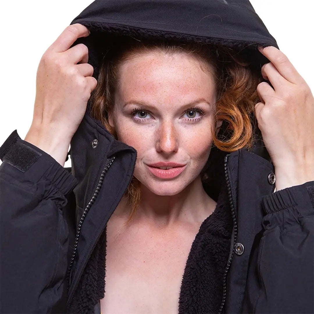 Woman with reddish hair in a black hooded jacket, perfect for a changing robe