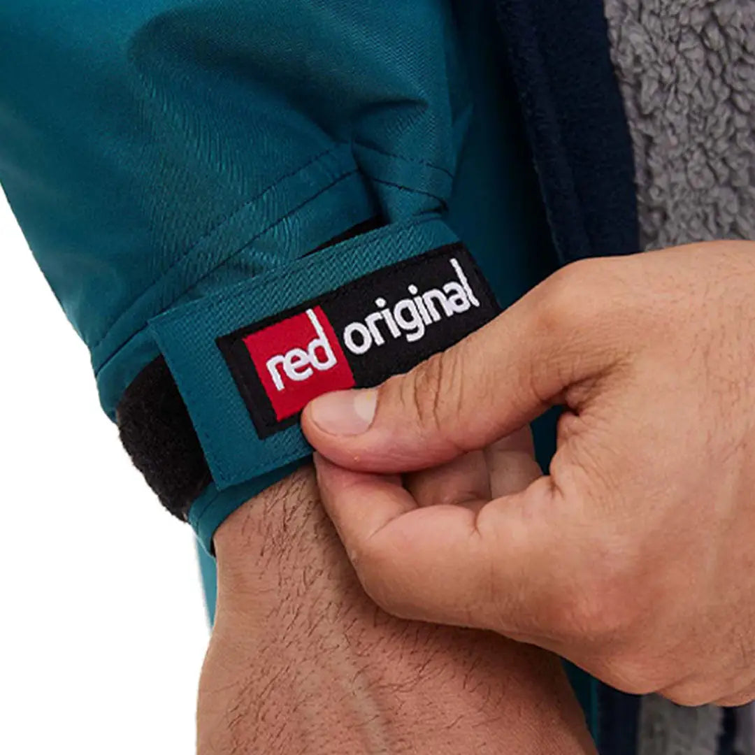 Hand holding a clothing label from the Red Pro Change Long Sleeve Evo Jacket