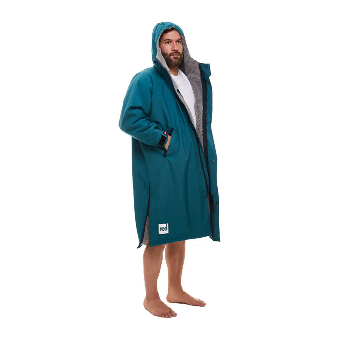 Bearded person in teal changing robe, showcasing the Red Pro Change Long Sleeve Evo Jacket