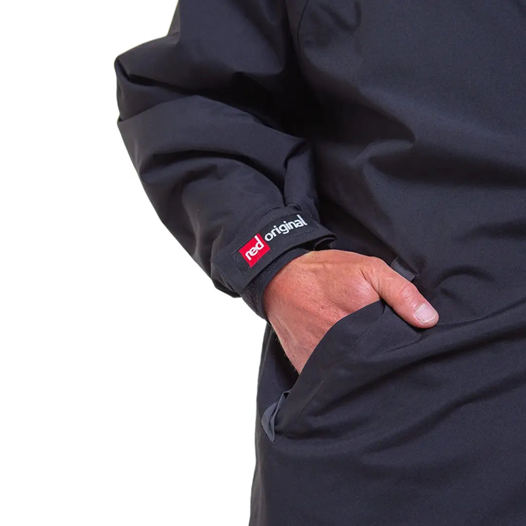 Black sleeve of Red Pro Change Long Sleeve Evo Jacket with hand in pocket and red logo