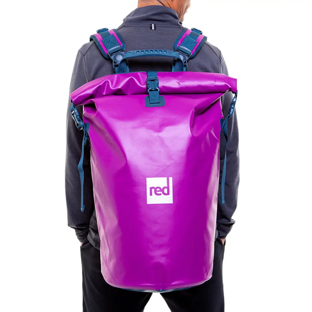 Bright purple waterproof backpack with teal straps and red logo, perfect dry bag for adventures