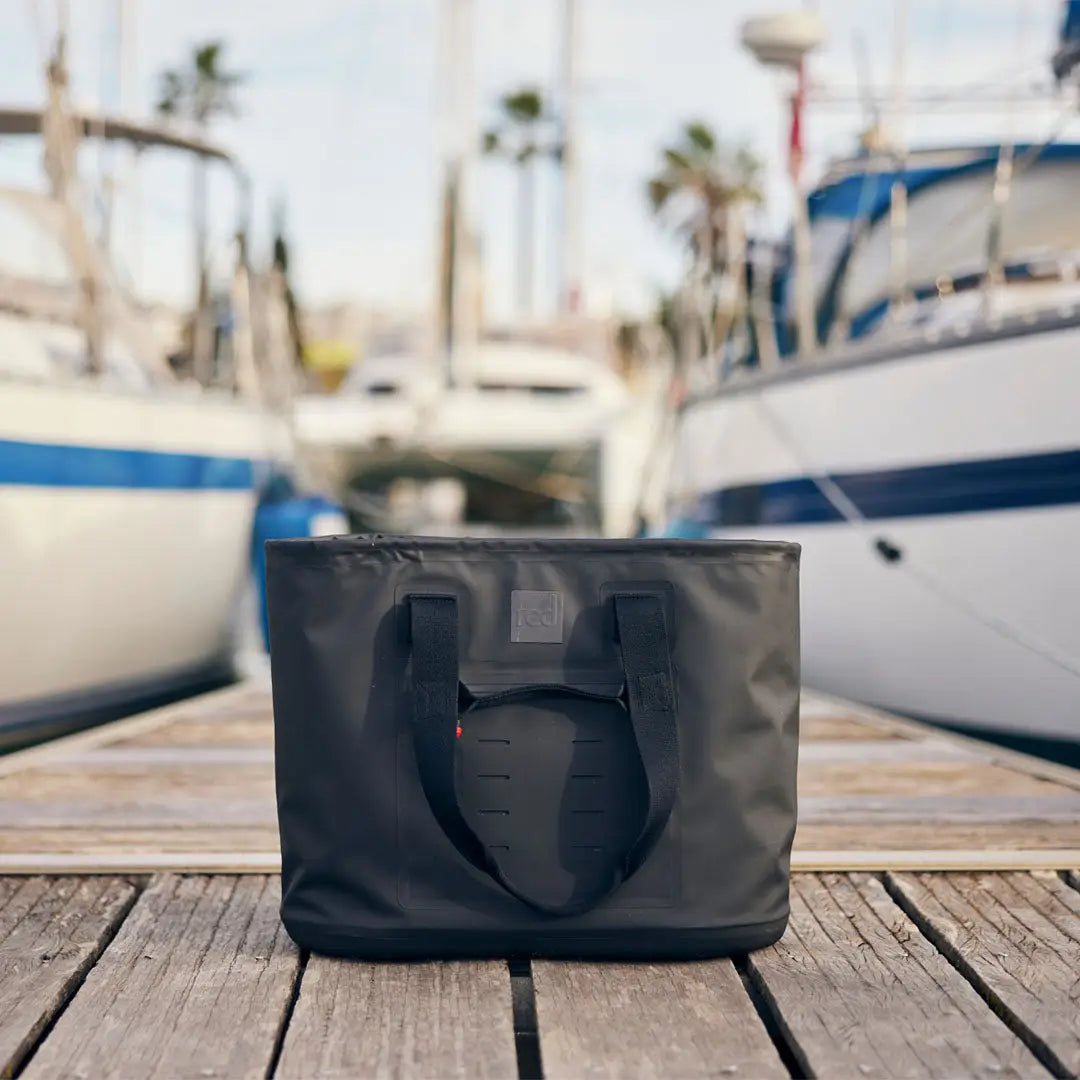 Dark gray tote bag with handles on wooden planks, perfect for a Red Waterproof Tote