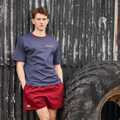 Young man in navy t-shirt and red shorts with a large tire, perfect for the outdoors