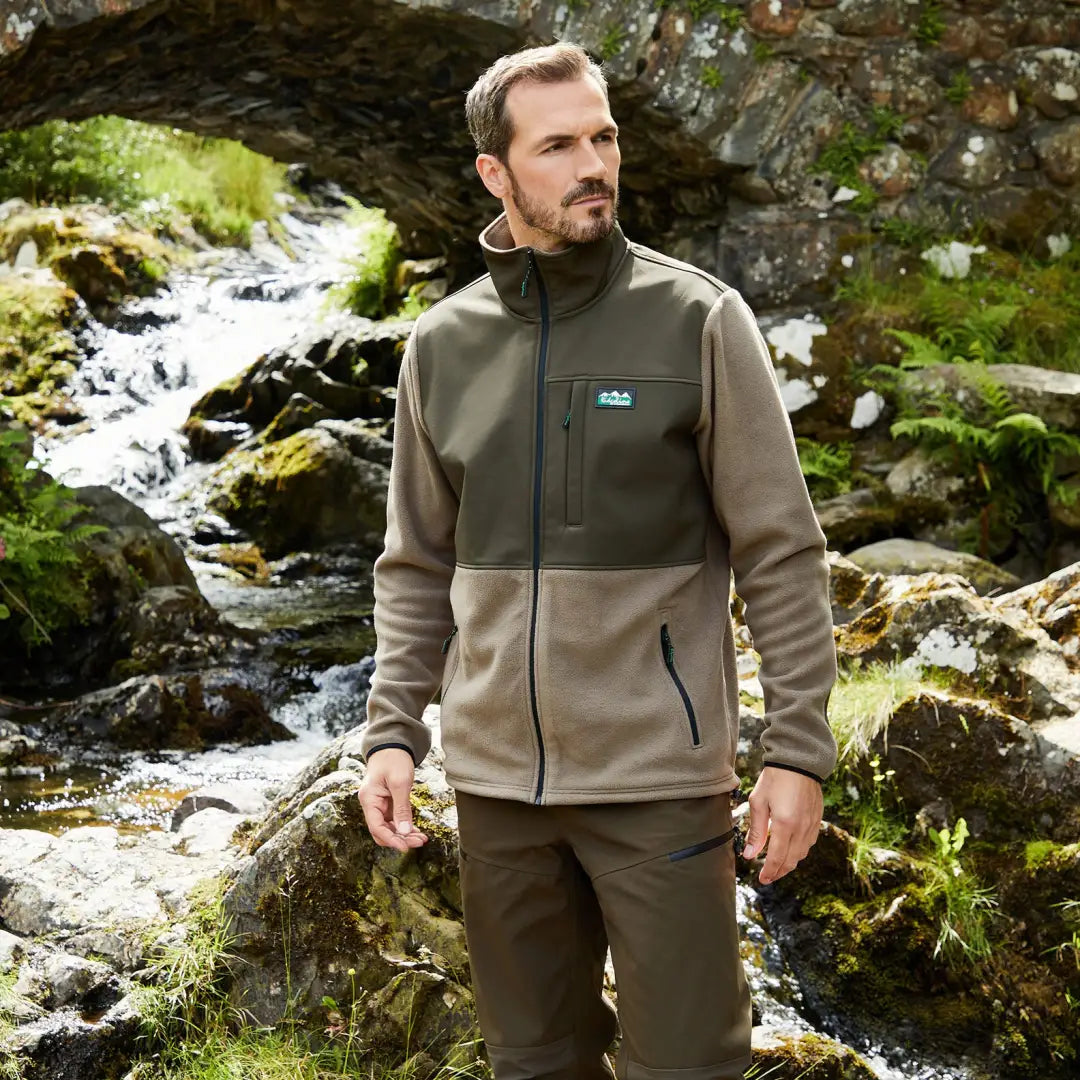 Man in Ridgeline Hybrid Men’s Fleece Jacket by a stream, perfect for country clothing and hunting