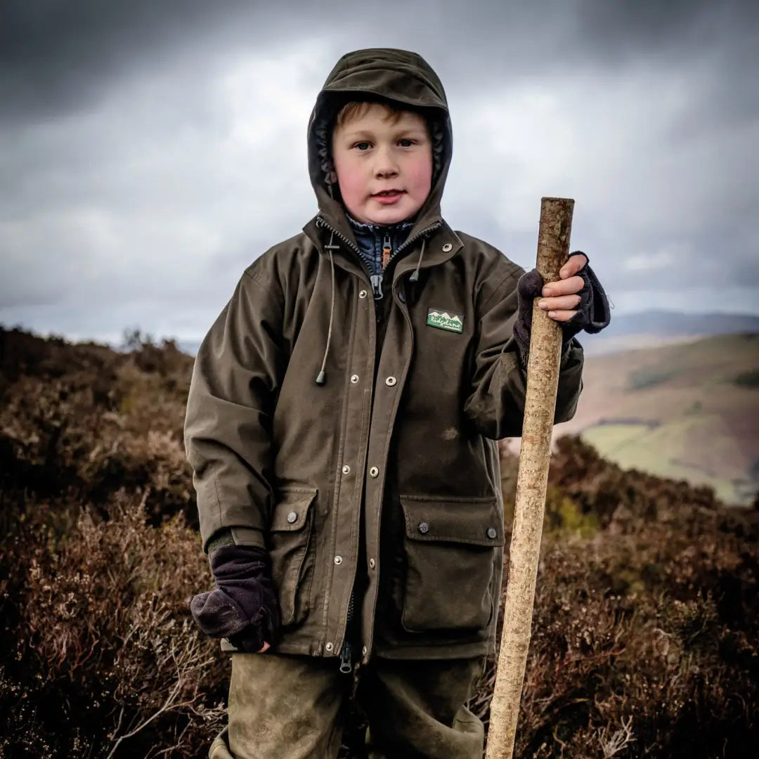 Child in Ridgeline Kids Spiker Jacket with walking stick, perfect for country clothing adventures