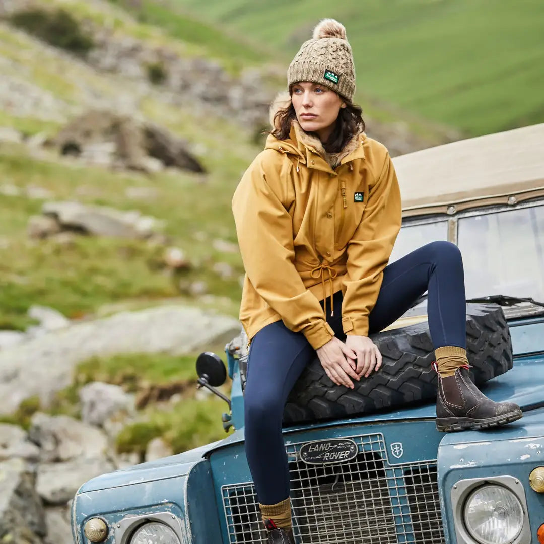 Woman in a yellow jacket on blue Land Rover wearing a Monsoon Nordic Smock