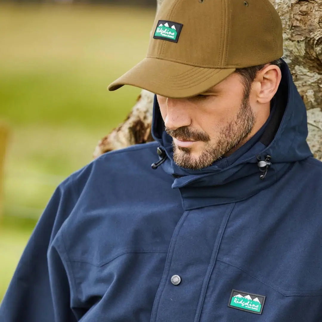 Man in tan baseball cap and navy jacket showing off the Monsoon Classic Cap style