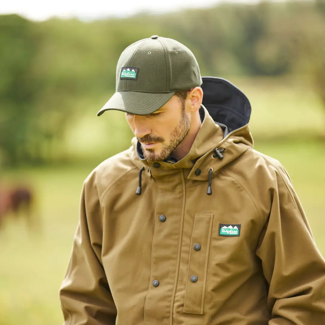 Man in a tan jacket and khaki cap showcasing Ridgeline Monsoon Classic Waterproof Jacket