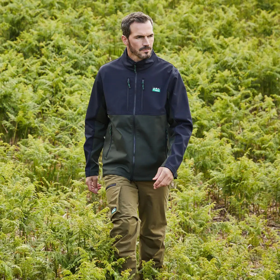 Man in a Ridgeline Ranger Jacket with khaki pants, surrounded by ferns