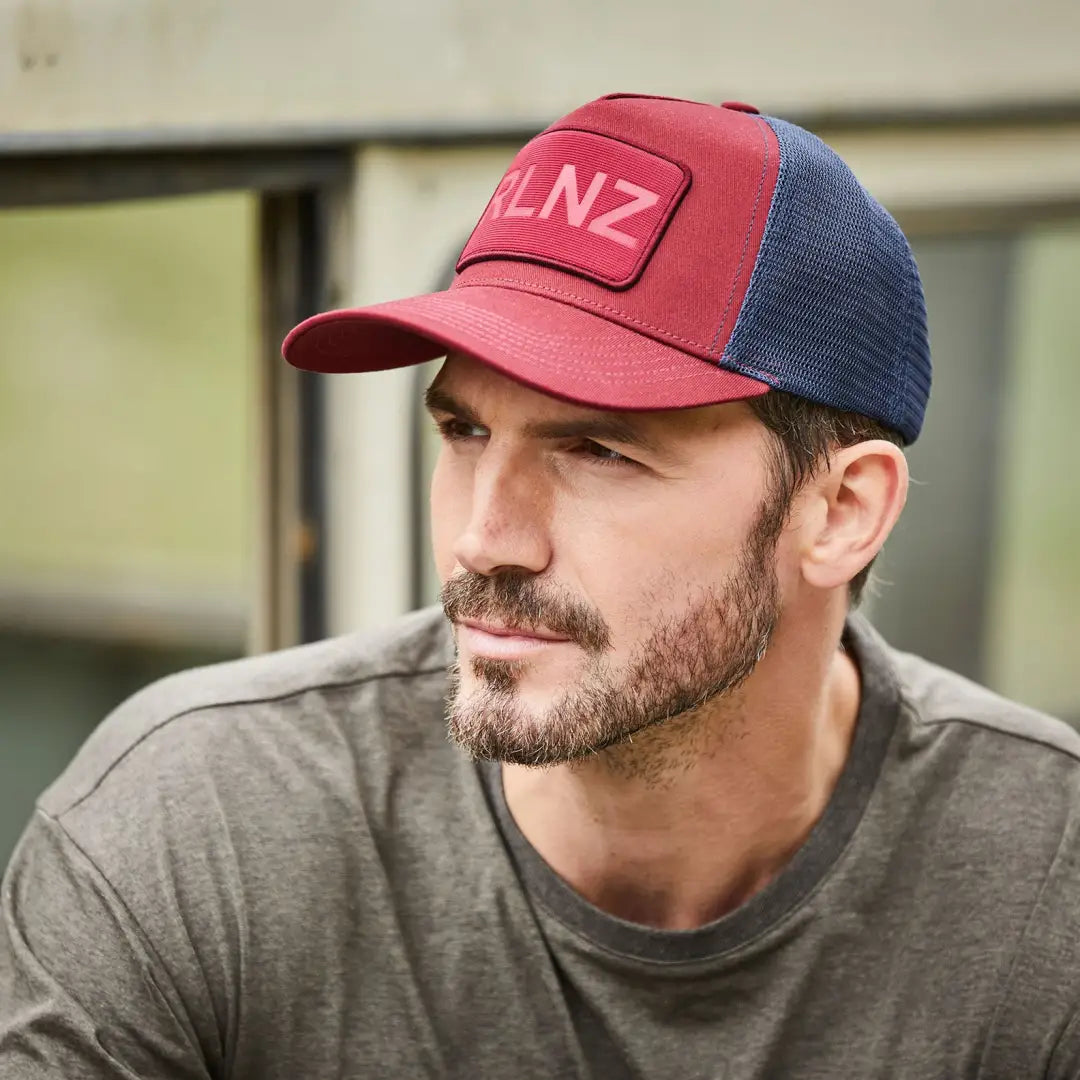 Bearded guy rocking a red and blue RLNZ Trucker Cap with logo