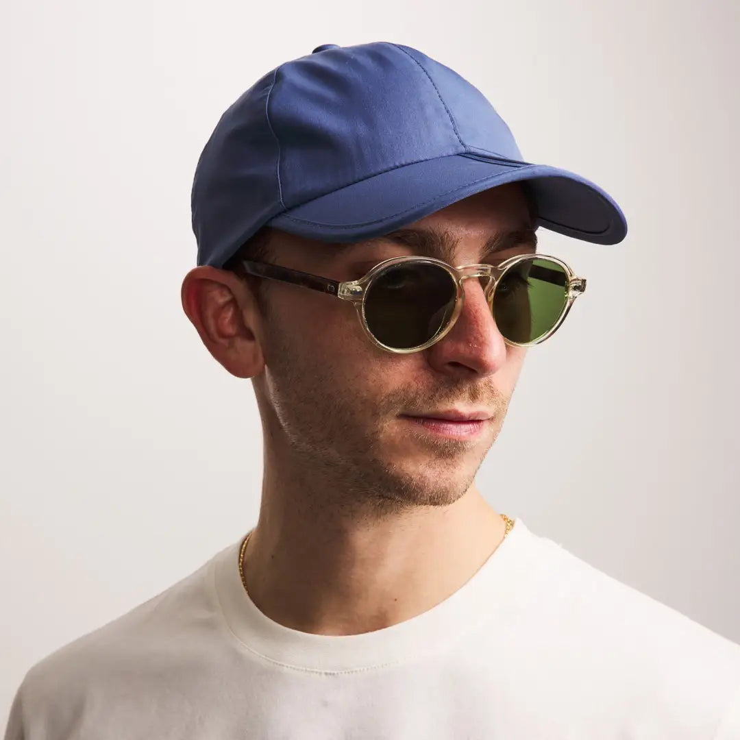 Man in a blue baseball cap and round sunglasses, perfect for the Sealskinz Salle Cap