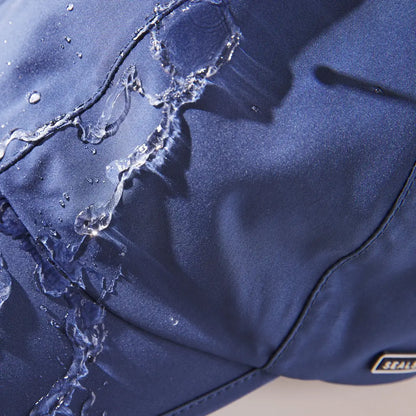 Torn blue fabric on Sealskinz Salle Cap with stitching and water droplets for country clothing